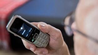 Ein älterer Menschen sitzt in seiner Wohnung und hält ein Telefon in der Hand. (Foto: Imago/Fotostand/K. Schmitt)