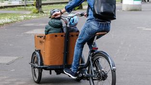 Zwei Kinder werden in einem Lastenrad gefahren.  (Foto: IMAGO / Michael Gstettenbauer)