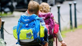 Ein Junge und ein Mädchen sind auf dem Weg zur Schule. (Foto: IMAGO / Michael Gstettenbauer)