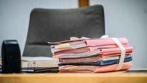 Prozessakten liegen auf dem Richtertisch in einem Gerichtssaal. (Foto: IMAGO / Funke Foto Services)
