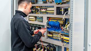 ückansicht eines Arbeiters, der ein elektrisches mechanisches System in einer Fabrik repariert.  (Foto: IMAGO / imagebroker / Unai Huizi)