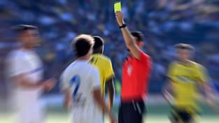 Ein Schiedsrichter zeigt einem Fußballspieler die gelbe Karte (Foto: IMAGO / Pius Koller)