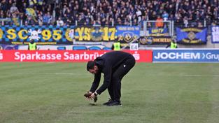Trainer Michel Kniat (Arminia Bielefeld) repariert den Rasen im Ludwigsparkstadion (Foto: IMAGO / Fussball-News Saarland)
