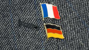 Kleine Anstecknadeln der Flaggen von Frankreich und Deutschland an einem Revers (Foto: IMAGO / Steinach)