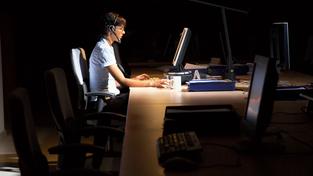Eine Angestellte sitzt alleine im dunklen Büro an einem Computerarbeitsplatz (Foto: IMAGO / YAY Images)