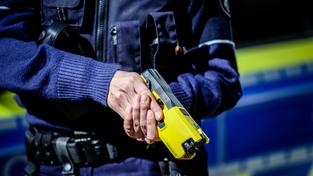 Eine Polizistin hält einen Taser in den Händen (Foto: IMAGO / Funke Foto Services)