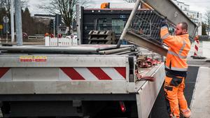 Personal der Straßensicherung hantiert mit Absperrbarken an der Ladefläche eines LKW (Foto: IMAGO / Funke Foto Services)