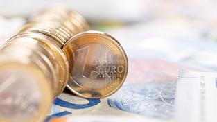 Ein-Euro-Münzen sind auf einem Geldschein drapiert (Foto: IMAGO / Aviation-Stock)