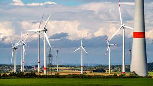 Windkraftanlagen stehen zwischen landwirtschaftlich genutzten Feldern (Foto: IMAGO / Jochen Tack)