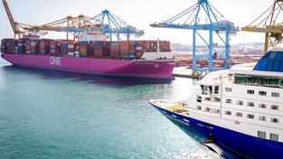 Ein Übersee-Frachtschiff steht im Container Hafen, davor ein Kreuzfahrtschiff (Foto: IMAGO / Political-Moments)