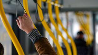 Ein Fahrgast hält sich im Bus an einer Halteschlaufe fest (Foto: IMAGO / suedraumfoto)