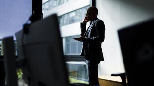 Ein Mann steht im Büro und telefoniert (Foto: IMAGO / photothek)
