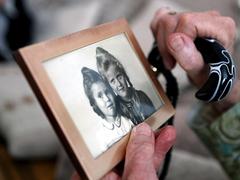 eine Seniorin hält ein Foto in den Händen (Foto: dpa)