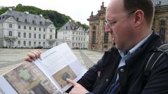 Markus Philipp mit seinem Buch „Saarbrücker Spurensuche“ vor der Saarbrücker Ludwigskirche (Foto: Peter Weitzmann)
