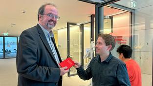 Thomas Lutze bekommt ein SPD-Parteibuch überreicht (Foto: Moritz Rödle)