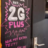 «Hier: 2G PLUS - Nur mit extra Test!» steht auf einem Schild an der geschlossenen Tür einer Bar in der Innenstadt. (Foto: picture alliance/dpa | Daniel Karmann)