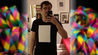 ein Mann steht mit einem schwarzes T-Shirt vor dem Spiegel. Auf dem schwarzen T-Shirt klebt ein weißes Blatt. (Foto: privat)