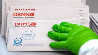 Eine Mitarbeiterin im DKMS Life Science Lab ordnet Briefe, in denen sich medizinische Wattestäbchen von möglichen DNA-Spendern befinden ein.  (Foto: picture alliance/dpa/dpa-Zentralbild | Robert Michael)