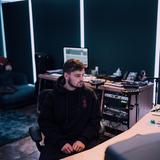 Martin Garrix sitzt in einem Studio und schaut seitlich auf einen Bildschirm. (Foto: Presse)