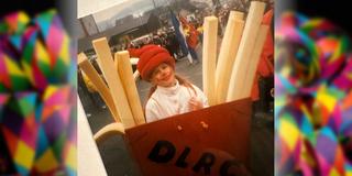 Ein Kind mit einem roten Hut. Drumherum sind selbstgebastelte große Pommes und eine Tüte. (Foto: privat)