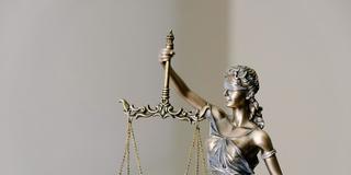 Illustration: Statue der Justitia mit Augenbinde und Waage (Foto: unsplash/Tingey Injury Law Firm)