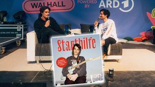 Sänger Zeck und Moderator Eren sitzen sich mit zwei Mikros gegenüber. Etwas weiter unten sieht man das Starthilfe-Cover mit Zeck. (Foto: Pressefoto)